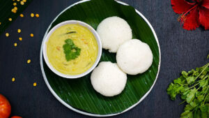 A plate of soft steamed idlis served with sambar and coconut chutney
