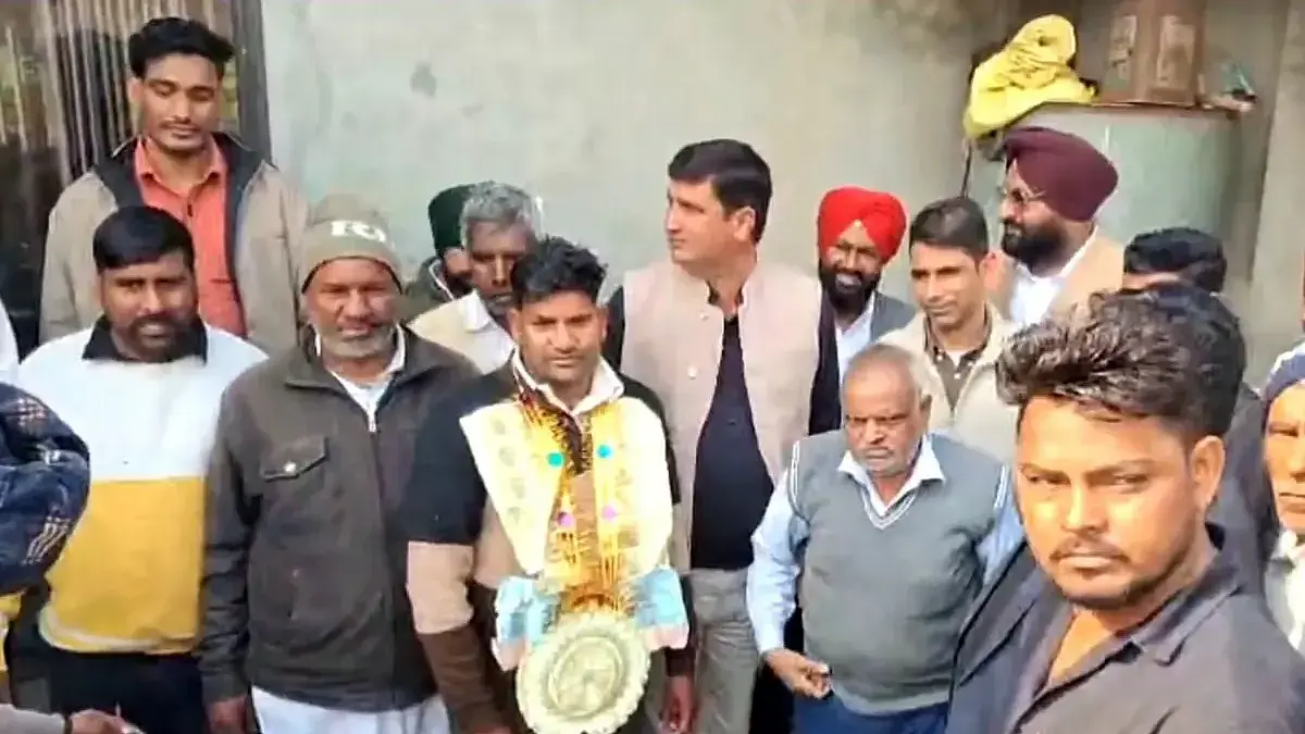 Villagers in Sirsa congratulating ₹10 crore lottery winner Prithvi Singh with garlands and celebrations outside his house.