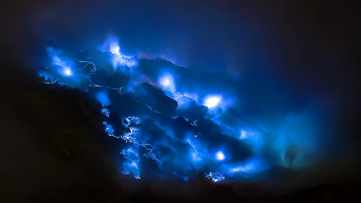 Intense blue sulfur flames emerging from Kawah Ijen crater wall in East Java during the night