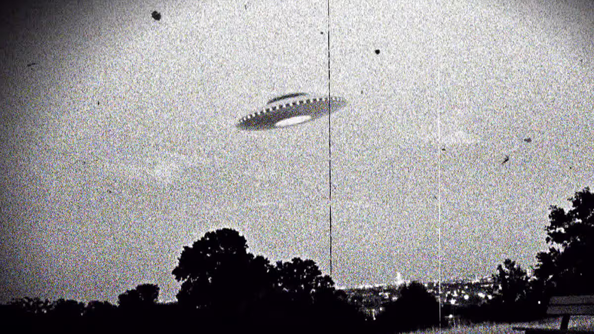 ఆకాశంలో ఎగురుతున్న ఫ్లయింగ్ సాసర్ ఆకారంలోని UFO బ్లాక్ అండ్ వైట్ చిత్రం