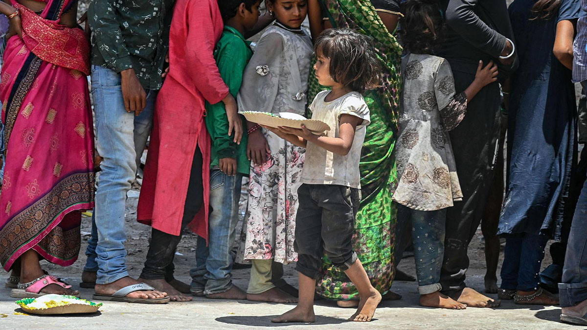 పిల్లలకు ఆహారం పంపిణీ చేస్తున్న స్ట్రీట్ కాజ్ కార్యక్రమంలో చిన్నారి చేతిలో ప్లేట్‌తో నిలిచిన దృశ్యం