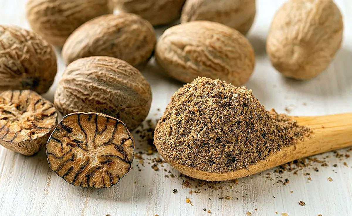 nutmeg powder closeup with whole nutmeg
