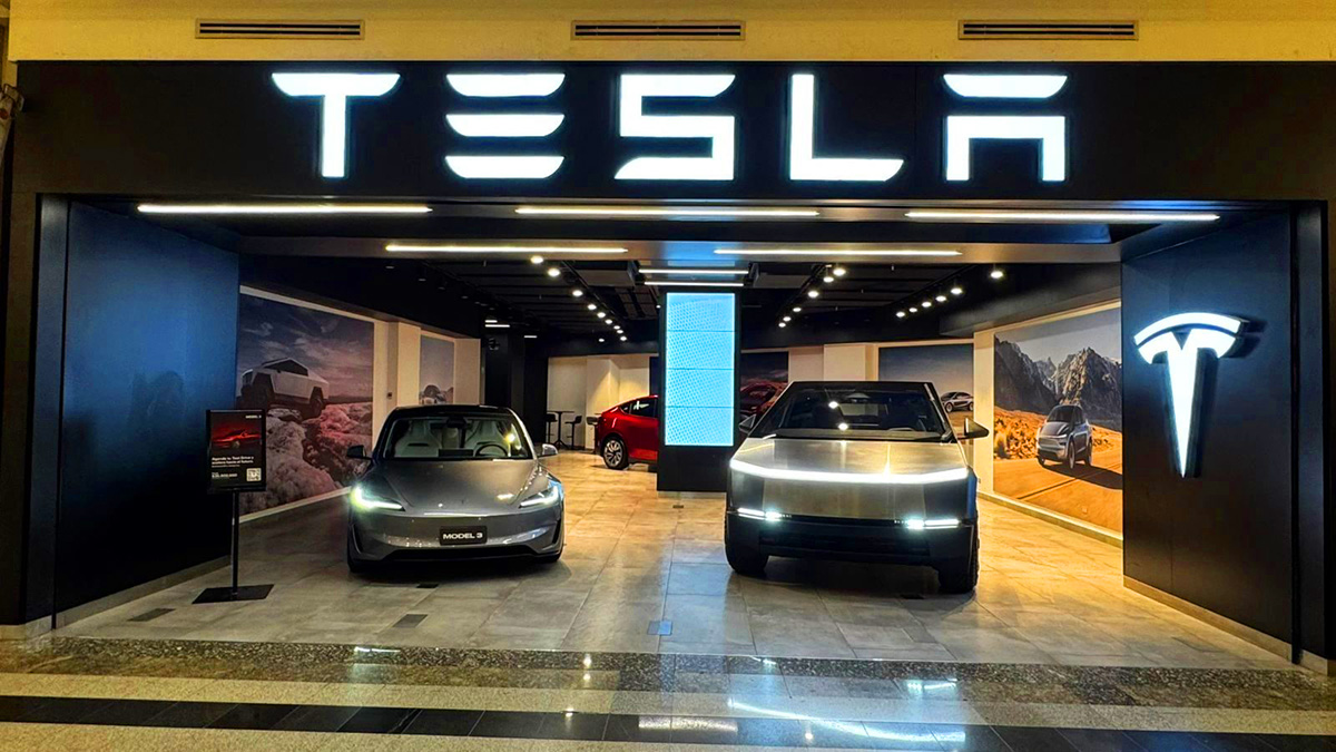 Tesla showroom displaying Model 3 and Cybertruck inside a modern electric vehicle store